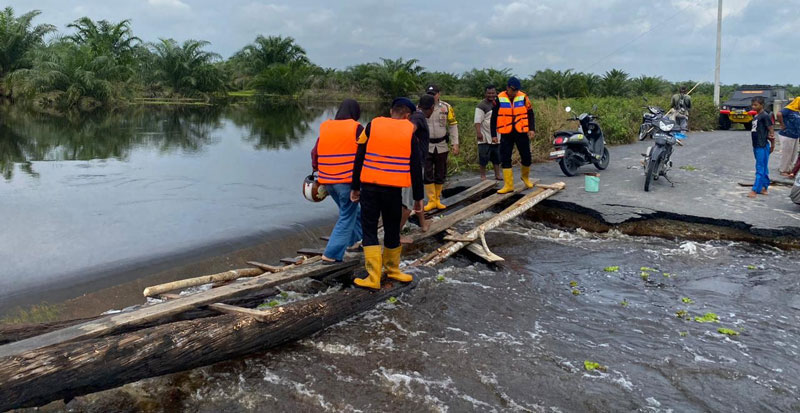 Tim SAR YON B Pelopor Brimobda Riau membangun jembatan darurat di atas jalan yang terputus akibat banjir, Rabu (13/12/2023).