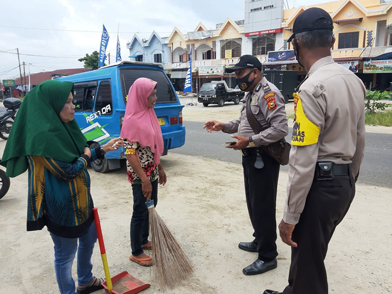 Masyarakat yang tidak memakai masker dan terjaring teking operasi yustisi melakukan sanksi sosial di Jalan Lintas Timur, Tenayan Raya. Kamis (1/10/2020). (POLSEK TENAYAN RAYA FOR RIAUPOS.CO)