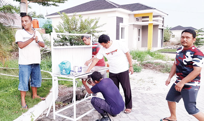 Warga Kompleks Villa Bunga membuat fasilitas cuci tangan dan sanitizer gratis untuk warga sekitar, Ahad (29/3/2020).(WARGA VILLA FOR RIAUPOS.CO)