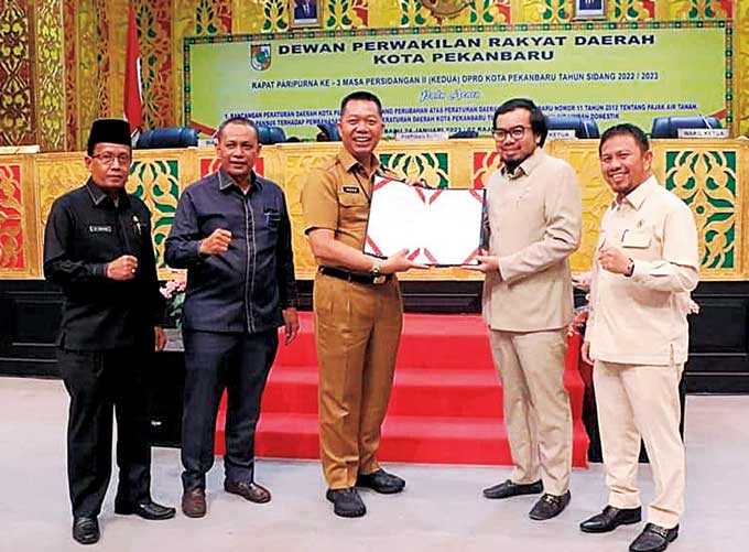 Pj Sekko Pekanbaru Indra Pomi Nasution (tengah) foto bersama dengan Wakil Ketua DPRD Kota Pekanbaru Ginda Burnama (dua kanan), Ketua Pansus Nurul Ikhsan (kanan), Plt Sekwan Idrus (kiri), dan Ketua Bapemperda Zulfahmi sambil memperlihatkan dokumen perda ya