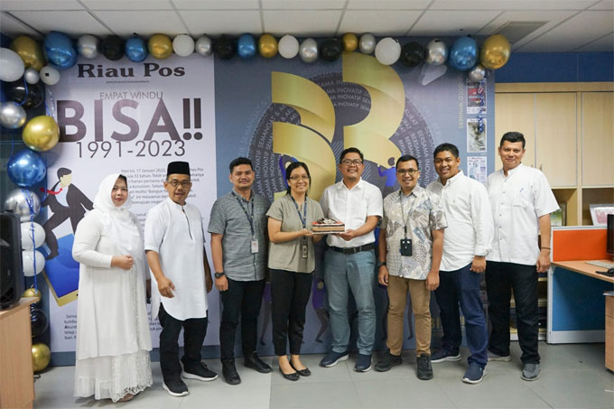 Direktur Utama Riau Pos Ahmad Dardiri (empat kanan) didamping Direktur Asmawi Ibrahim (dua kanan) dan direksi Riau Pos menerima kue tar dariÂ  Mal Living World Pekanbaru saat HUT ke-32 Riau Pos di Graha Pena Riau, Pekanbaru, Selasa (17/1/2023).