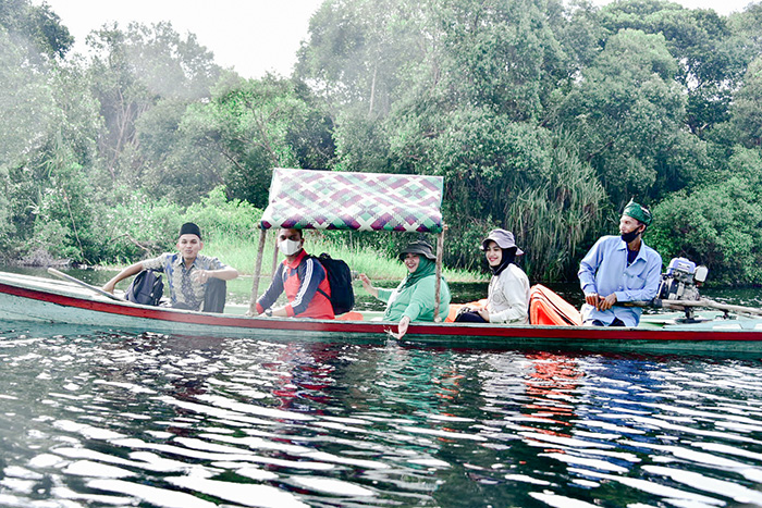 Bupati Bengkalis  Kasmarni menaiki perahu menyusuri sungai menuju Dusun Benio Desa Tasik Serai, Kecamatan Talang Muandau, Jumat (16/2021).