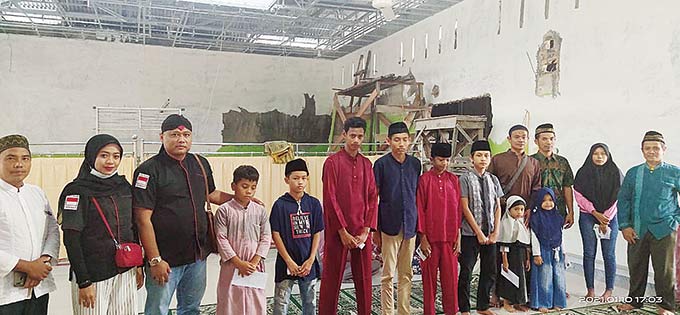 Ketua Reog Singo Mbalelo Pekanbaru, Sulamto (tiga kiri) berfoto bersama anak yatim dan pengurus  Panti Asuhan Yayasan Baithul Al-Anshor Al-Islami, Rumbai usai menyerahkan bantuan, Ahad (10/1/2021).(MUSLIM NURDIN (RIAUPOS.CO)