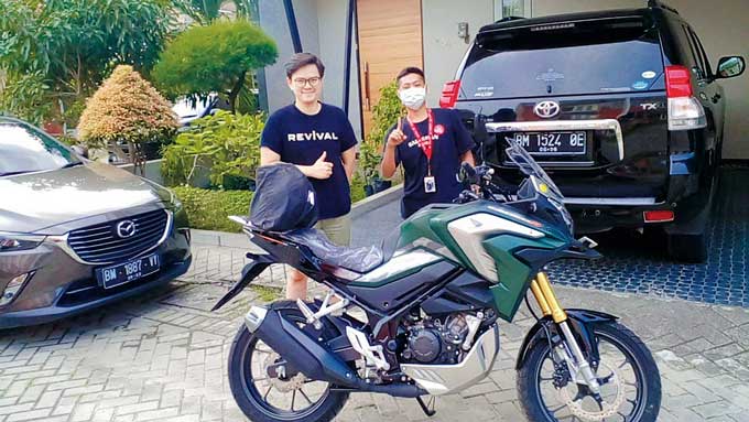 Wei Yanto (kiri) menerima hadiah satu unit sepeda motor Honda CB150X dari undian nobar Piala Dunia Qatar di Novotel yang bekerja sama dengan Honda dan Riau Pos, baru-baru ini.