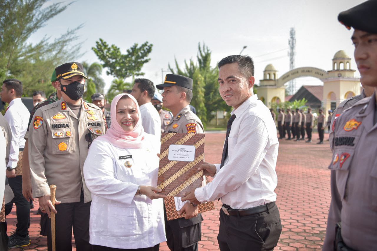 Bupati Bengkalis Kasmarni menyerahkan penghargaan terhadap pegawai Kantor Imigrasi (Kanim) Kelas II TPI Bengkalis dan Personel Polres Bengkalis yang berprestasi dalam pelaksanaan tugas,  di Halaman Mapolres Bengkalis, Rabu (30/11/2022).
