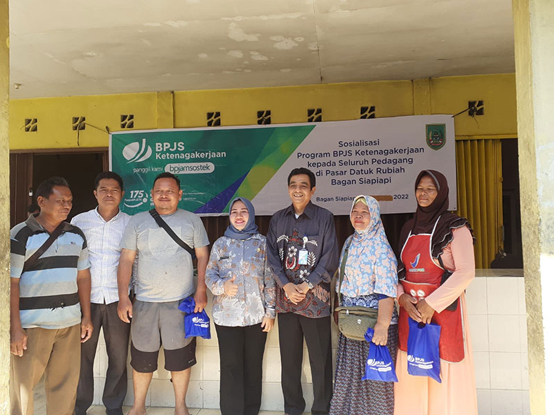Kepala Cabang BPJS Naker Rohil, Wahyu Fauzi dan Kabid Pengembangan Perdagangan Dalam Negeri Disperindag, Delta Norantika foto bersama sejumlah pedagang usai sosialisasi yang digelar di Pasar Tradisional Datuk Rubiah di Bagansiapiapi, Kamis (15/9/2022).