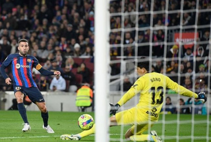 Bek kiri Barcelona Jordi Alba (kiri) menendang bola untuk mencetak gol pembuka saat mengalahkan Sevilla 3-0 dalam lanjutan Liga Spanyol di Stadion Camp Nou, Barcelona, Senin (6/2/2023) dini hari WIB.