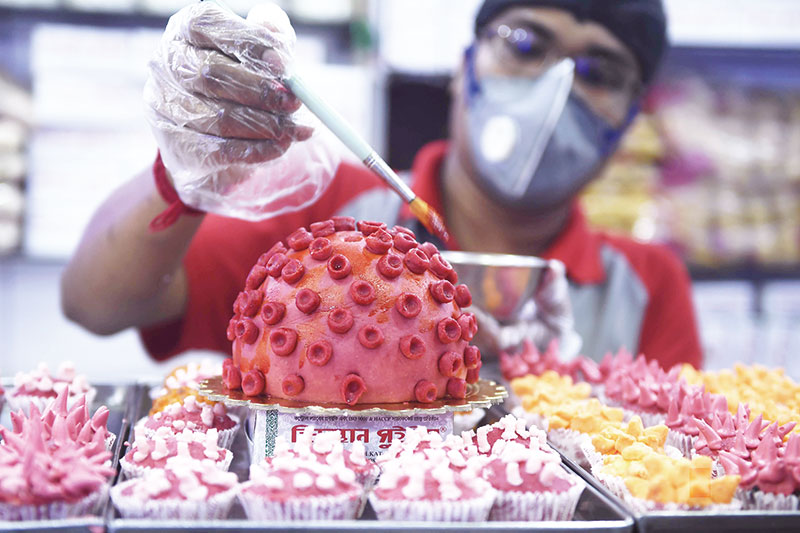 Seorang pekerja memberikan sentuhan akhir pada permen corona di sebuah toko selama lockdown di Kolkata, India, Senin (6/4/2020).(DIBYANGAHU SARKAR/AFP)