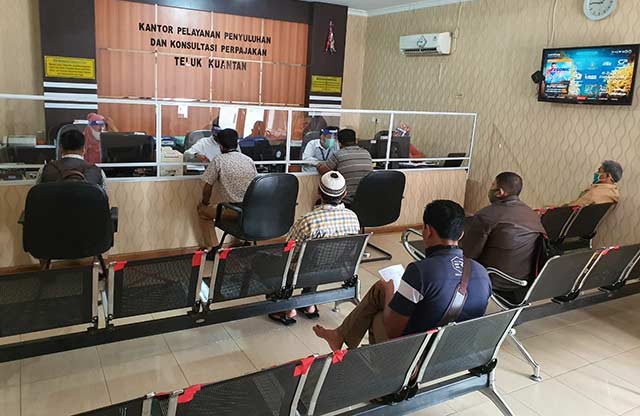 Para wajib pajak terlihat antre dengan tetap mengedepankan protokol kesehatan saat berada di kantor KP2KP Telukkuantan, Rabu (17/6/2020). Mardias Chan/Riau Pos