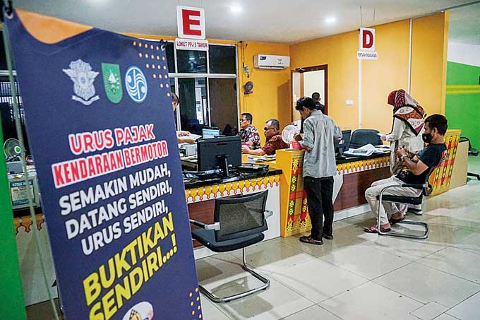 Masyarakat melakukan pengurusan dan pembayaran Pajak Kendaraan Bermotor di Kantor Samsat Bapenda Riau, Jalan Gajah Mada dengan memanfaatkan pemutihan denda pajak kendaraan bermotor, Pekanbaru, Kamis (9/2/2023).