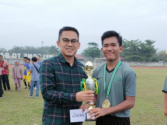 Anggota DPD/MPR RI Edwin Pratama Putra SH menyerahkan piala Kampar Super League kepada pemain PTPN V U-15 di Stadion Tuanku Tambusai Bangkinang Kota, Senin (26/12/2022).