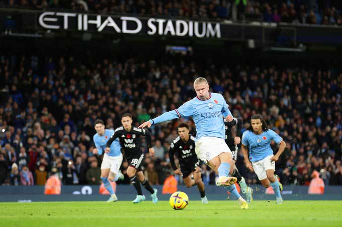 Penyerang Manchester City, Erling Haaland, mengeksekusi penalti ke jala Fulham saat injury time dalam lanjutan Liga Inggris di Stadion Etihad, Sabtu (5/11/2022).