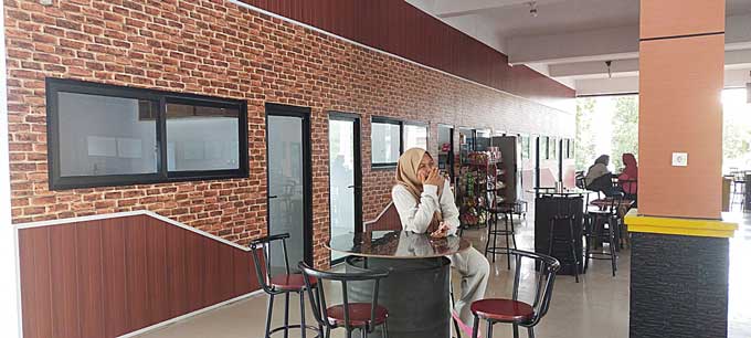 Penumpang Ro-Ro Sungai Selari Pakning duduk santai di ruang tunggu sambil menikmati fasilitas ruang tunggu yang nyaman seperti ruangan kafe, baru-baru ini.