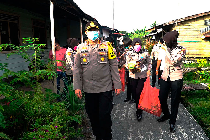 Polwan Polresta Pekanbaru dipimpin Kapolresta Pekanbaru Kombes Pol Nandang Muâ€™min Wijaya, berbagi tali asih kepada warga Kampung Terendam, Kecamatan Rumbai, Jumat (8/5/2020).(bayu/riau pos)
