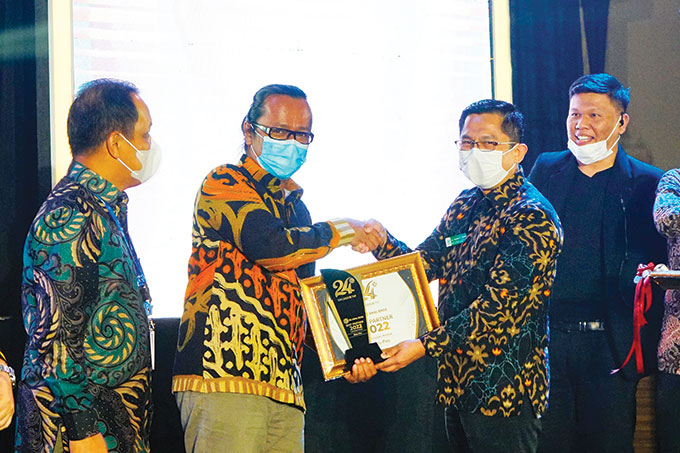 Direktur RS Awal Bros Ujungbatu dr Vandra Yovano MARS menyerahkan trofi dan piagam penghargaan kepada Direktur Riau Pos Firman Agus di Hotel Pangeran, Pekanbaru, Senin (29/8/2022).