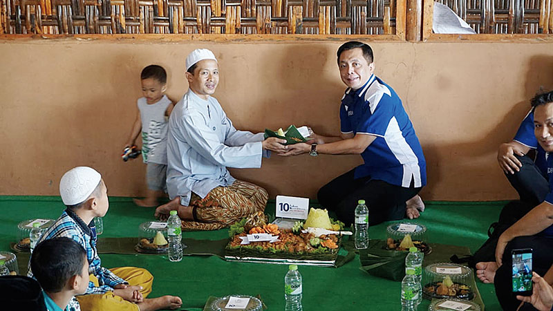 CEO DHM Andhy Irawan MBA (kanan) saat memberikan potongan tumpeng kepada pengurus Panti Asuhan Al Idria Gunung Pati Semarang M Syafie, Selasa (7/7/2020).(DHM FOR RIAUPOS.CO)