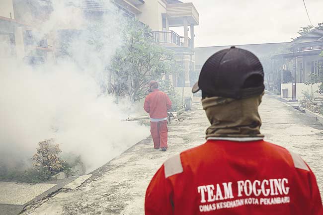 FOGING: Petugas Dinas Kesehatan Kota Pekanbaru melakukan pengasapan (fogging) di permukiman warga di Jalan Melur, Kecamatan Tampan, Pekanbaru, Rabu (20/2/2019).  MHD AKHWAN/RIAU POS