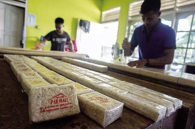 MEMBUAT TEMPE: Pekerja membuat tempe di rumah industri di Jalan Kuantan VII, Kota Pekanbaru, beberapa waktu lalu. MHD AKHWAN/RIAUPOS