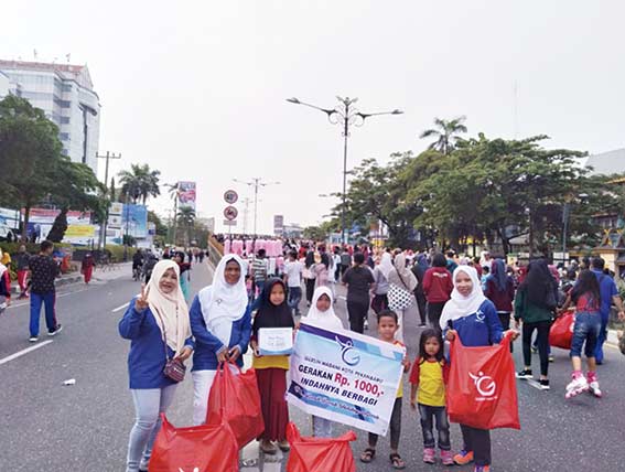 BERSIH: Anggota Komunitas Gersih dengan membawa kantong plastik besar melakukan aksi bersih-bersih sepanjang areal CFD, Ahad (24/3/2019).