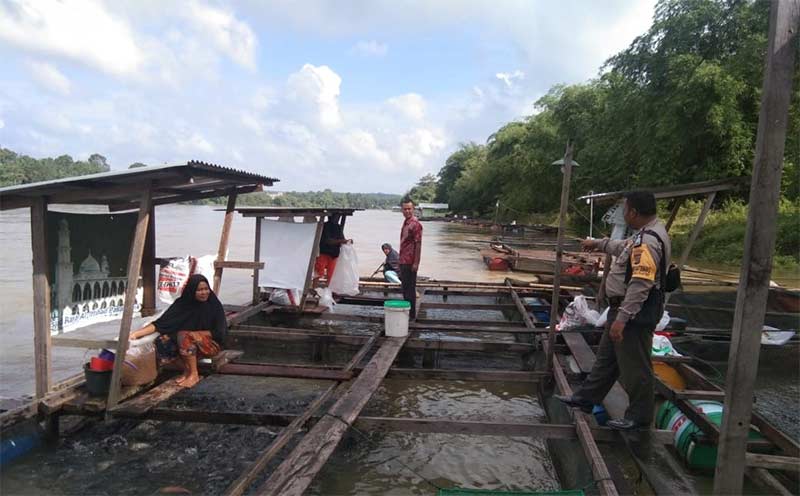 Bhabinkamtibmas Kecamatan Kuok Bripka Wawan A Harahap lakukan sosialisasi terkait pelepasan pintu Spillway PLTA Koto Panjang kepada pemilik keramba di Desa Merangin, pagi ini, (HENDARWAN KARIMAN/RIAUPOS.CO)