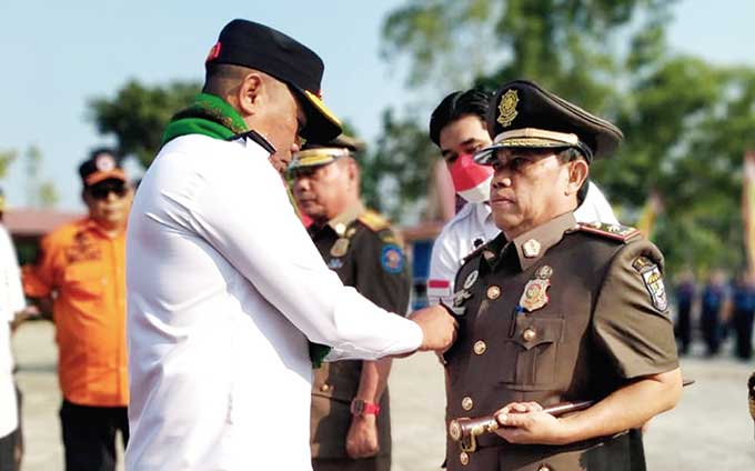Bupati Pelalawan H Zukri menyematkan pin kepada Tengku Junaidi MAp saat memimpin apel serah terima jabatan kepala Satpol PP dan Damkar Pelalawan di halaman Kantor Bhakti Praja Pangkalankerinci, Rabu (10/8/2022).