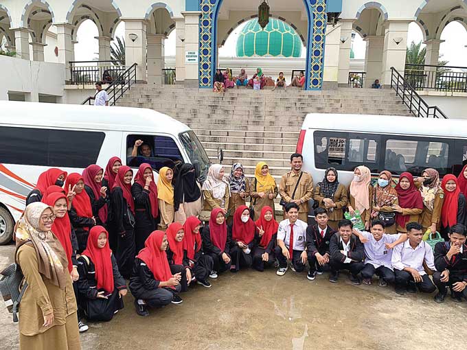 Sejumlah pengunjung foto bersama saat mengisi liburan di objek wisata Hapanasan, Kecamatan Rambah, Kabupaten Rokan Hulu,Â  Senin (26/12/2022).