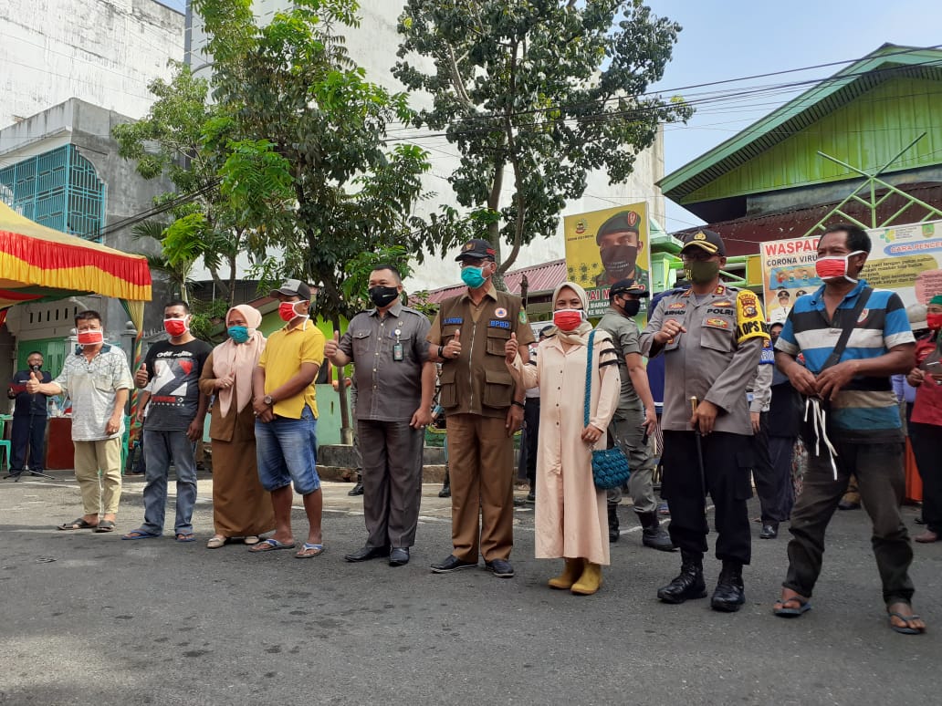 Kapolres Rohil AKBP Nurhadi SH SIk dan Bupati Rohil H Suyatno AMp foto bersama sejumlah pedagang di depan Pasar Datuk Rubiah di Bagansiapiapi, Selasa (16/6). (ZULFADHLI/WWW.RIAUPOS.CO)