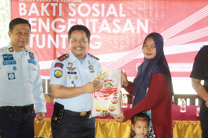 Kepala Rutan Rengat Julius Barus SE MH menyerahkan bantuan sembako kepada salah seorang warga pada kegiatan sosial dalam upaya pengentasan tengkes, Sabtu (29/7/2023).
