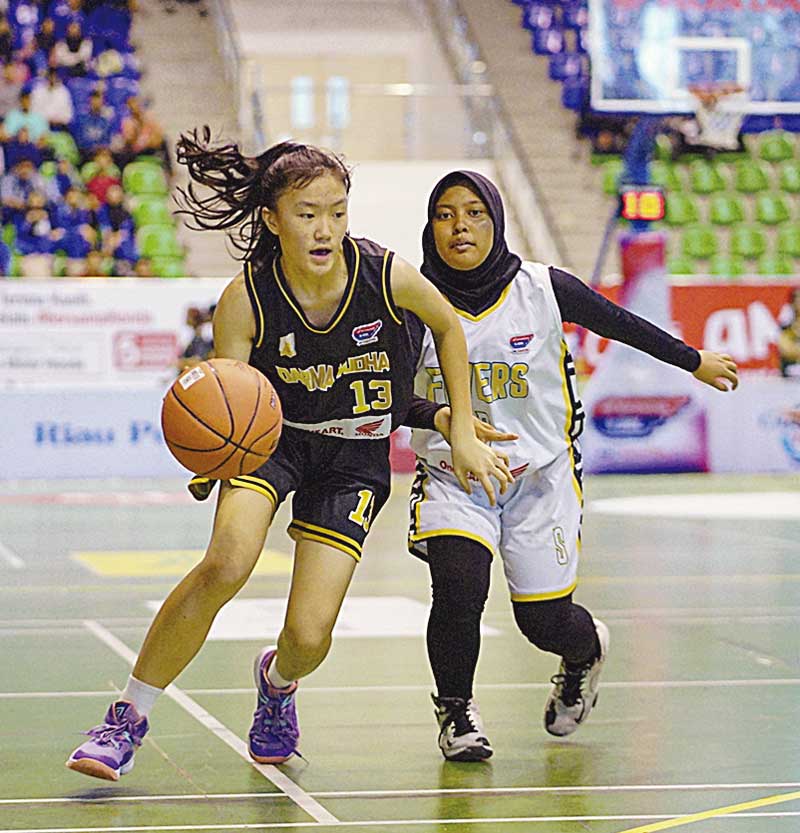 Pemain SMA Darma Yudha Pekanbaru Kathleen Myer Wulin (kiri) berusaha melewati pemain SMAN 5 Pekanbaru pada ajang Honda DBL With Kopi Good Day Riau Series di Gelanggang Remaja, Pekanbaru, Kamis (30/11/2023).
