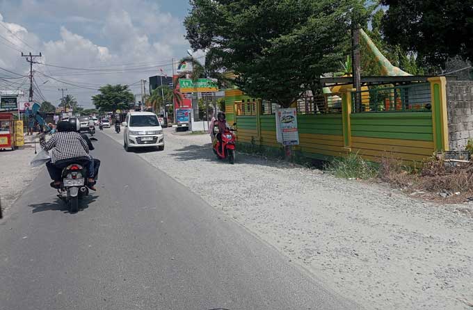 Pengendara melewati Jalan Suka Karya, Kecamatan Tuah Madani, Pekanbaru, yang baru diaspal ulang (overlay) di sebagian ruas badan jalan, Kamis (25/5/2023).
