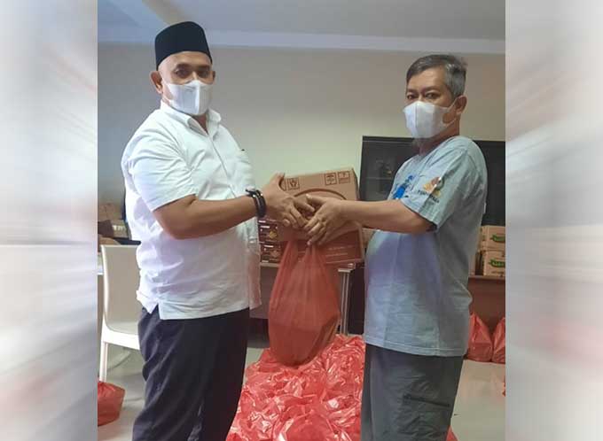 Ketua PWI Riau H Zulmansyah Sekedang menyerahkan paket bingkisan kepada Ketua Pokja PWI Kota Pekanbaru Ardiansyah MZ Tanjung, kemarin.