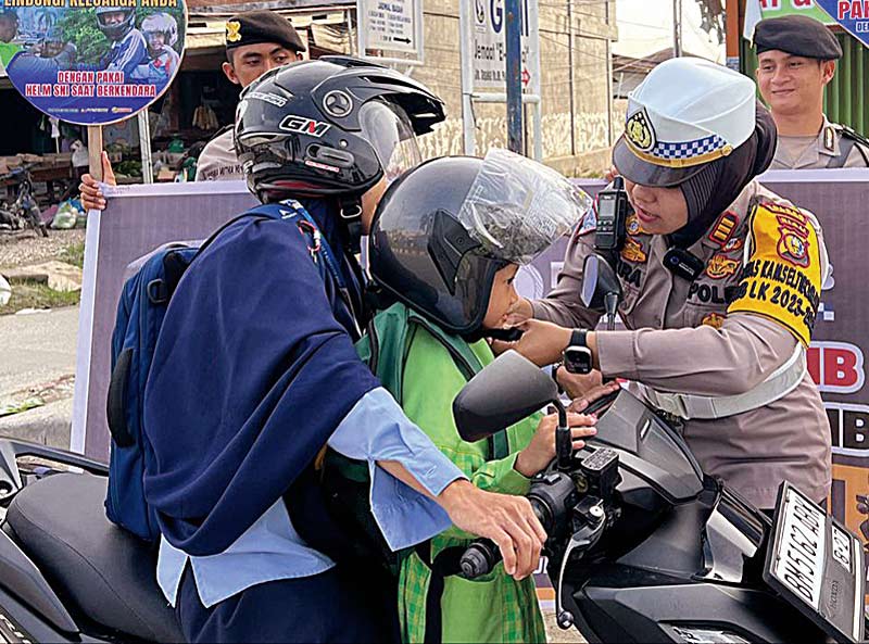 Kasat Lantas Pelalawan AKP Akira Ceria SIK MM memberikan helm dan tumbler minuman gratis kepada pengendara sepeda motor sebagai reward taat dan tertib berlalu lintas di wilayah Kabupaten Pelalawan, Kamis (23/11/2023) di Jalan Lintas Timur Pangkalan Kerinc