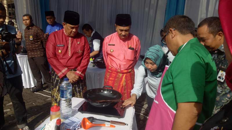 KOMPOR INDUKSI: Gubernur Riau Syamsuar dan Wakil Gubernur Riau Edy Natar Nasution melihat cara penggunaan kompor induksi di gedung Dharma Wanita Provinsi Riau,  beberapa waktu lalu.(PLN WKWR FOR RIAU POS)