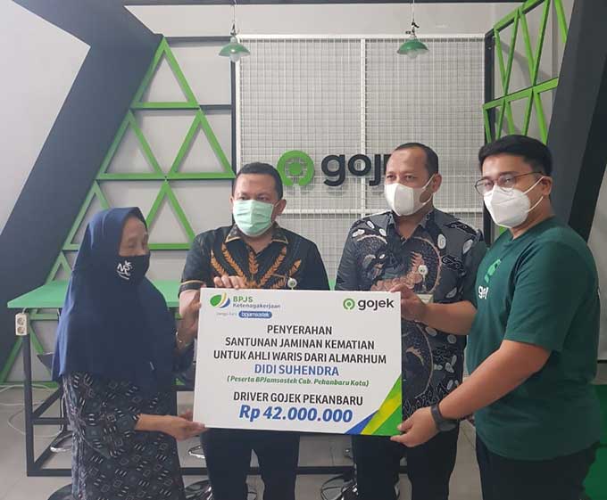 Kepala BPJS Ketenagakerjaan Pekanbaru Kota Uus Supriyadi didampingi Kabid Kepesertaan BPJS Ketenagakerjaan Pekanbaru Kota Dodi Pramana Â menyerahkan santunan jaminan kematian kepada ahli waris driver Gojek Rusmawati didampingiÂ Branch Manager Gojek Kota P