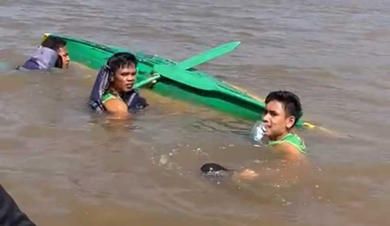 Anak pacu Festival Pacu Sampan Pulau Semut meÂ­Â­ngÂ­apung saat sampan mereka karam, sebelum diselamatkan Tim SAR di Pekanbaru, Sabtu (5/8/2023).