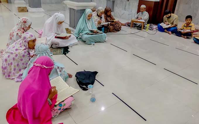 Sejumlah anak dan orang dewasa mengikuti tadarus Alquran di Masjid Al Qadariyah, Jalan Delima Pekanbaru, Ahad (18/4/2021). Kegiatan ini merupakan salah satu bentuk upaya untuk meramaikan masjid.