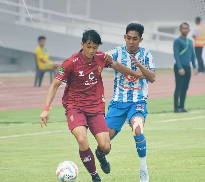 Pemain PSPS Riau Firman Septian (Jersey (putih biru) berusaha mendapatkan bola dari pemain Sriwijaya FC (Jersey merah, Ahad (8/10/203) di Stadion Jakabaring Palembang.