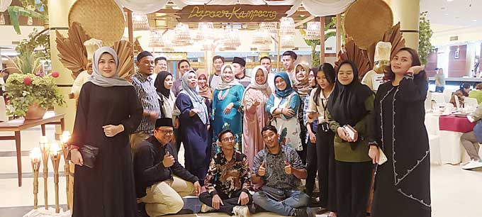 General Manager Grand Elite Hotel Pekanbaru Lusiyanti (tengah hijau tosca) berfoto bersama para mitra media dengan latar pintu masukÂ Dapoer Kampoeng.