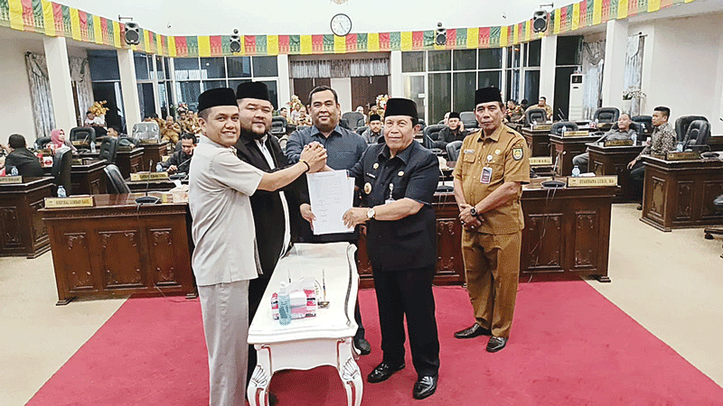 Bupati Rohul H Sukiman didamping Pimpinan DPRD Rohul Novli Wanda Ade Putra ST MSi, Wakil Ketua DPRD Rohul Nono Patria Pratama SE menunjukkan berita acara KUA PPAS Tahun 2024 yang tela ditandatangani bersama dalam rapat paripurna di Gedung DPRD Rohul, Seni