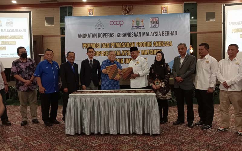 Ketua Kadin Provinsi Riau H Masuri SH (baju putih) mewakili Indonesia bersama Anggota Lembaga Angkatan Koperasi Kebangsaan Malaysia Berhad (Angkasa) Datoâ€™ Hj Kamarudin Ismail (baju biru) menyerahkan dokumen kerja sama dalam memajukan produk UMKM di Hote