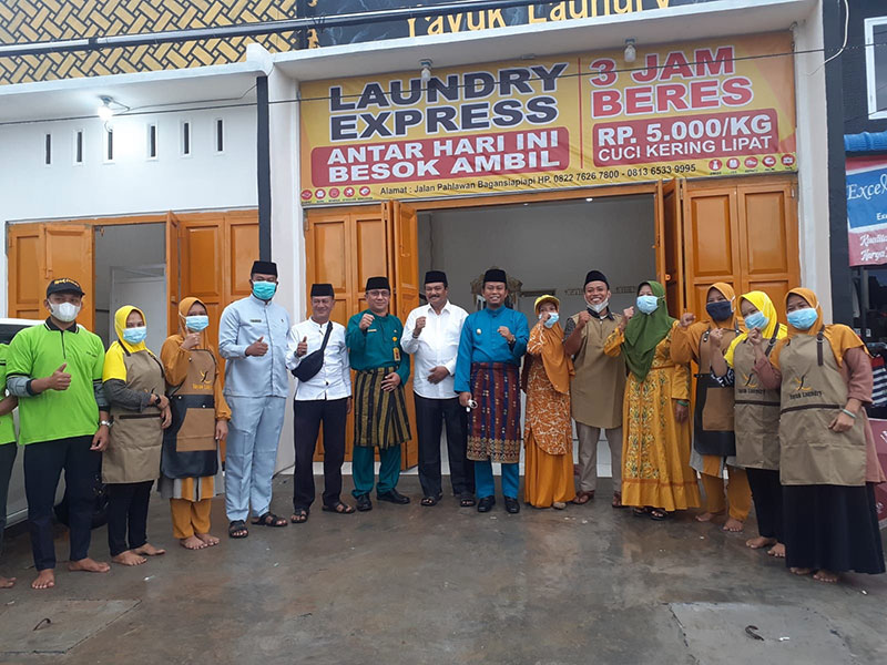 Wabup Rohil H Sulaiman SS MH foto bersama Kadis DPMPTSP Acil Rustianto MSi, Plt Kadisenda Cicik M Athar MSi, dan owner serta karyawan Yayuk Laundry usai peresmian di Bagansiapiapi, Jumat (10/12/2021).
