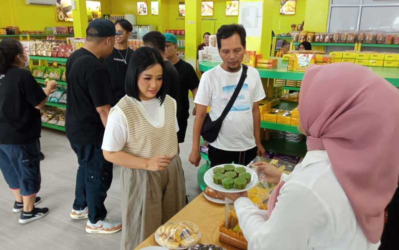 Penyanyi Astrid saat membeli bolu kemojo di salah satu toko oleh-oleh khas Riau di Pekanbaru, Jumat (25/8/2023).
