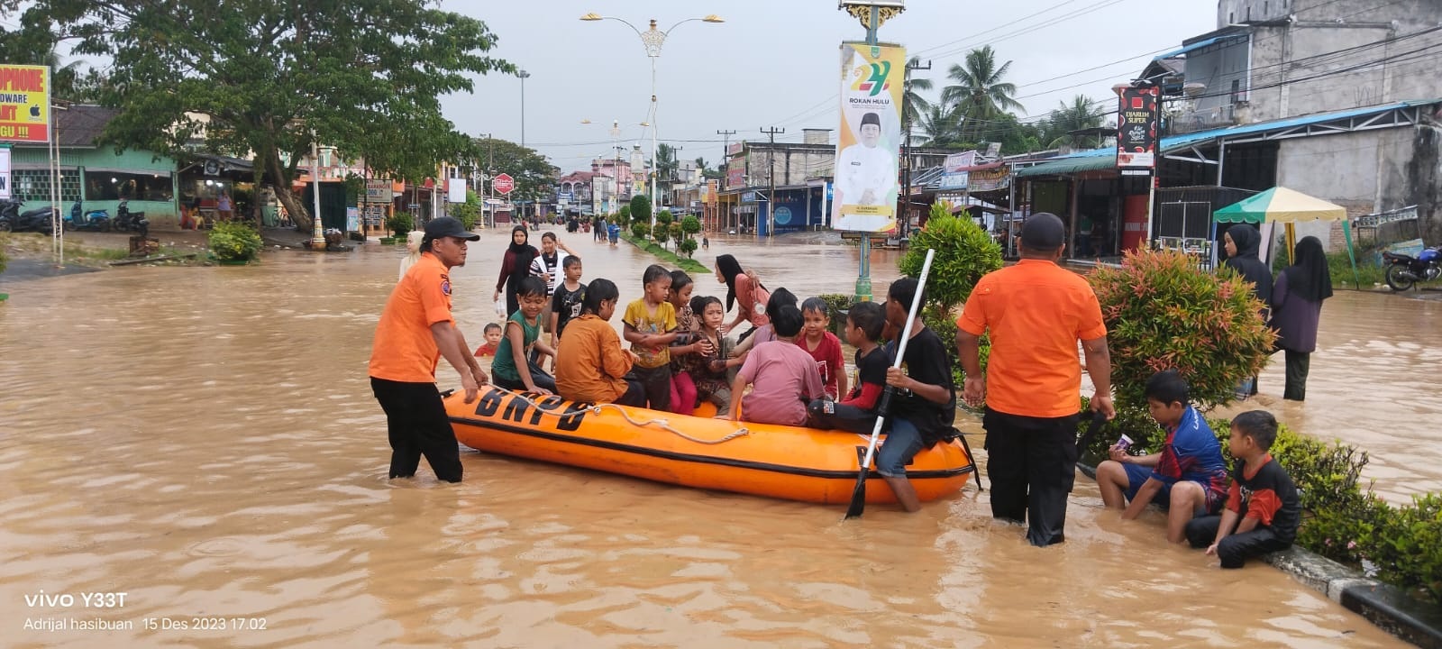 Petugas BPBD Rohul memberikan bantuan evakuasi kepada masyarakat menggunakan perahu karet akibat meluapnya air Sungai Batang Lubuh, Jumat (15/12/2023) petang.