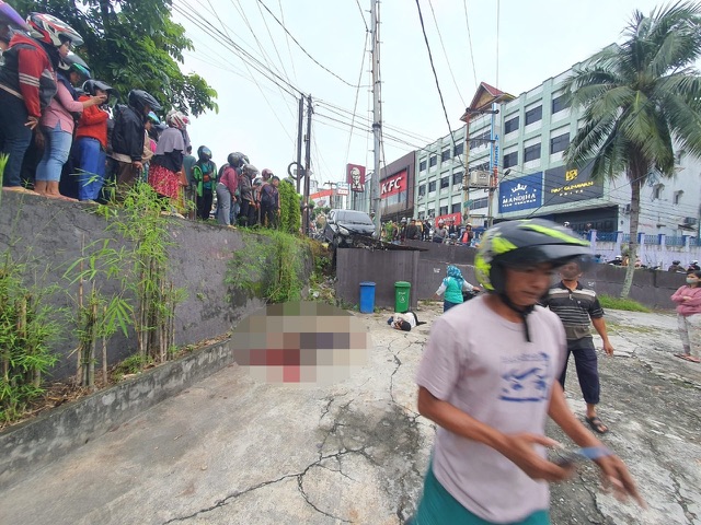 Warga yang melintas melihat korban lakalantas maut di Simpang Jalan Pandan-Sudirman, Rabu (11/1/2023) pagi.