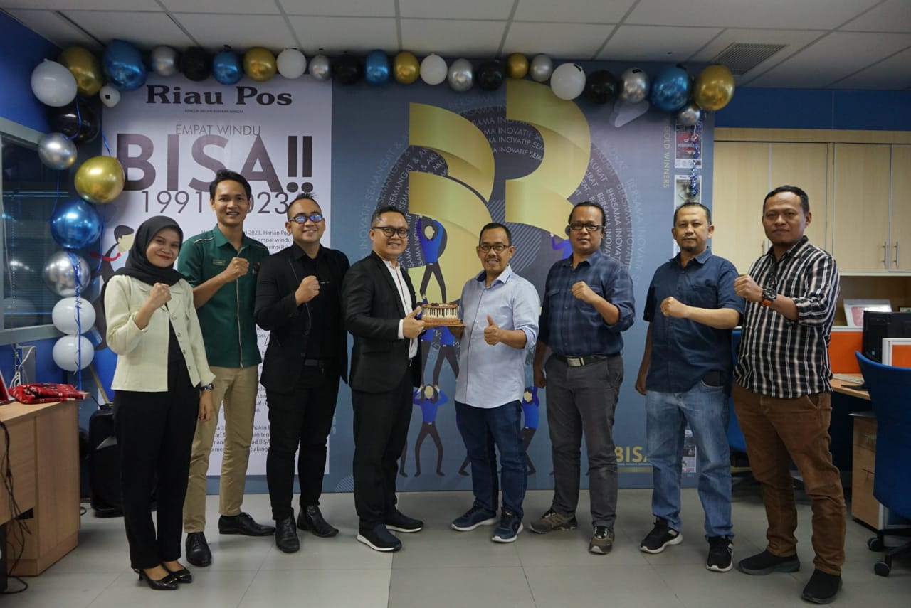 Direktur Riau Pos Asmawi Ibrahim (empat kanan) serta Direktur dan Pemimpin Redaksi Riau Pos Firman Agus (empat kiri) dan Manajer Iklan Riau Pos Sumaryono serta tim menerima kue ulang tahun dari Executive Assistant Manager Hotel Mutiara Merdeka Aguswandi,