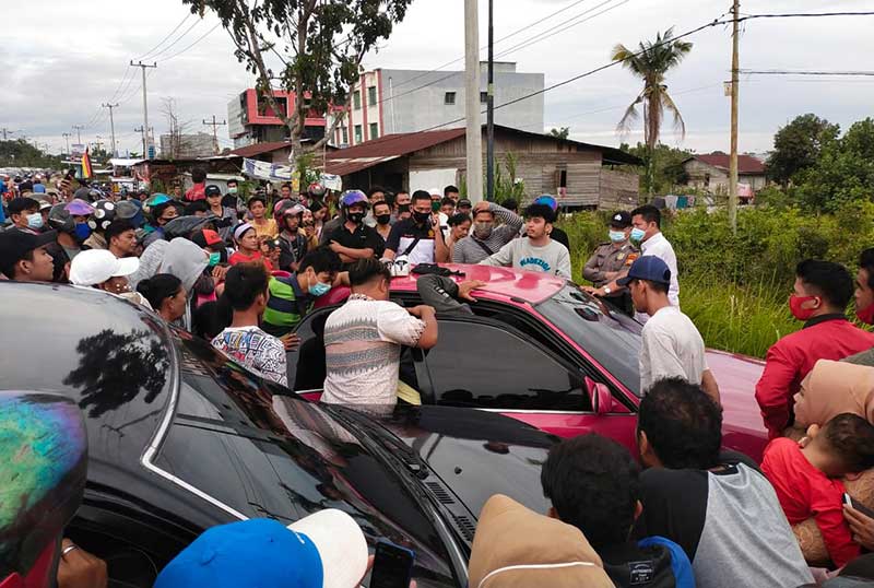 Sebuah mobil berwarna merah terlihat sedang digeledah oleh aparat kepolisian di Jl Yos Sudarso, Kawasan Rumbai, Pekanbaru, Sabtu (9/1/2021). Kejadian tersebut membuat jalan tersebut macet total hampir dua jam. (SOFIAH/RIAUPO.CO)