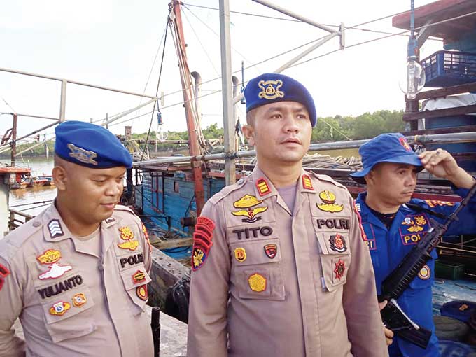 Kasat Polairud Polres Rohil AKP Tito Laragatra SIK MH didampingi personel di depan kapal motor yang diamankan terkait penggunaan alat tangkap trawl di Bagansiapiapi, Rabu (8/6/2022).