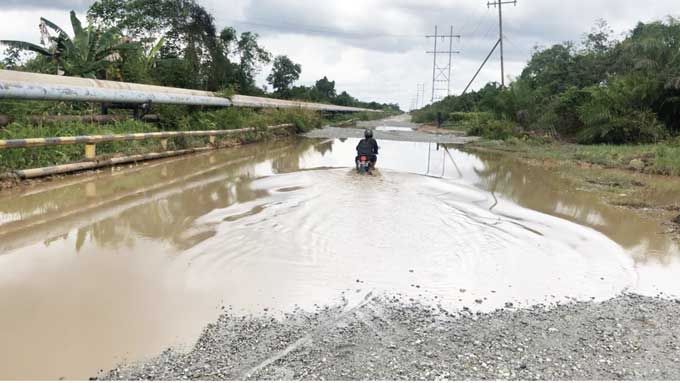 Kubangan yang berbentuk seperti kolam di Jalan Lintas Teluk Masjid, Sungai Apit-Simpang Â Doral atau Simpang Obor, Kecamatan Pusako, Kabupaten Siak,  Selasa (20/12/2022).