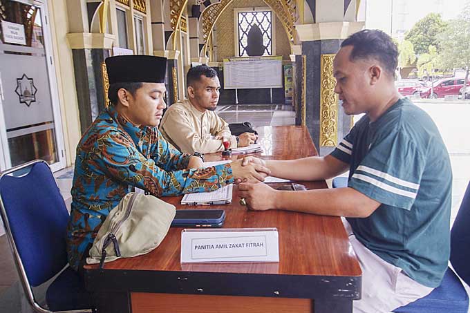 Jemaah membayar zakat fitrah di Masjid Paripurna Agung Ar Rahman Pekanbaru, Jumat (14/4/2023). Umat muslim sudah dapat membayar zakatnya di setiap Unit Pembayaran Zakat (UPZ) yang ada di sekitar rumah.