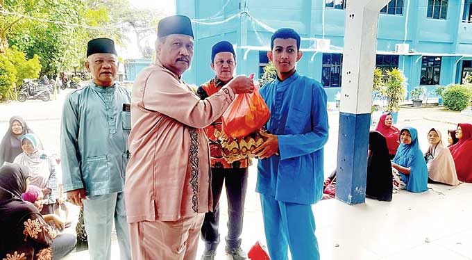 Kepala SMAN 8 Pekanbaru H Tavip Tria Candra SPd MM menyerahkan paket bansos Ramadan kepada siswa dari keluarga kurang mampu, Jumat (14/4/2023).